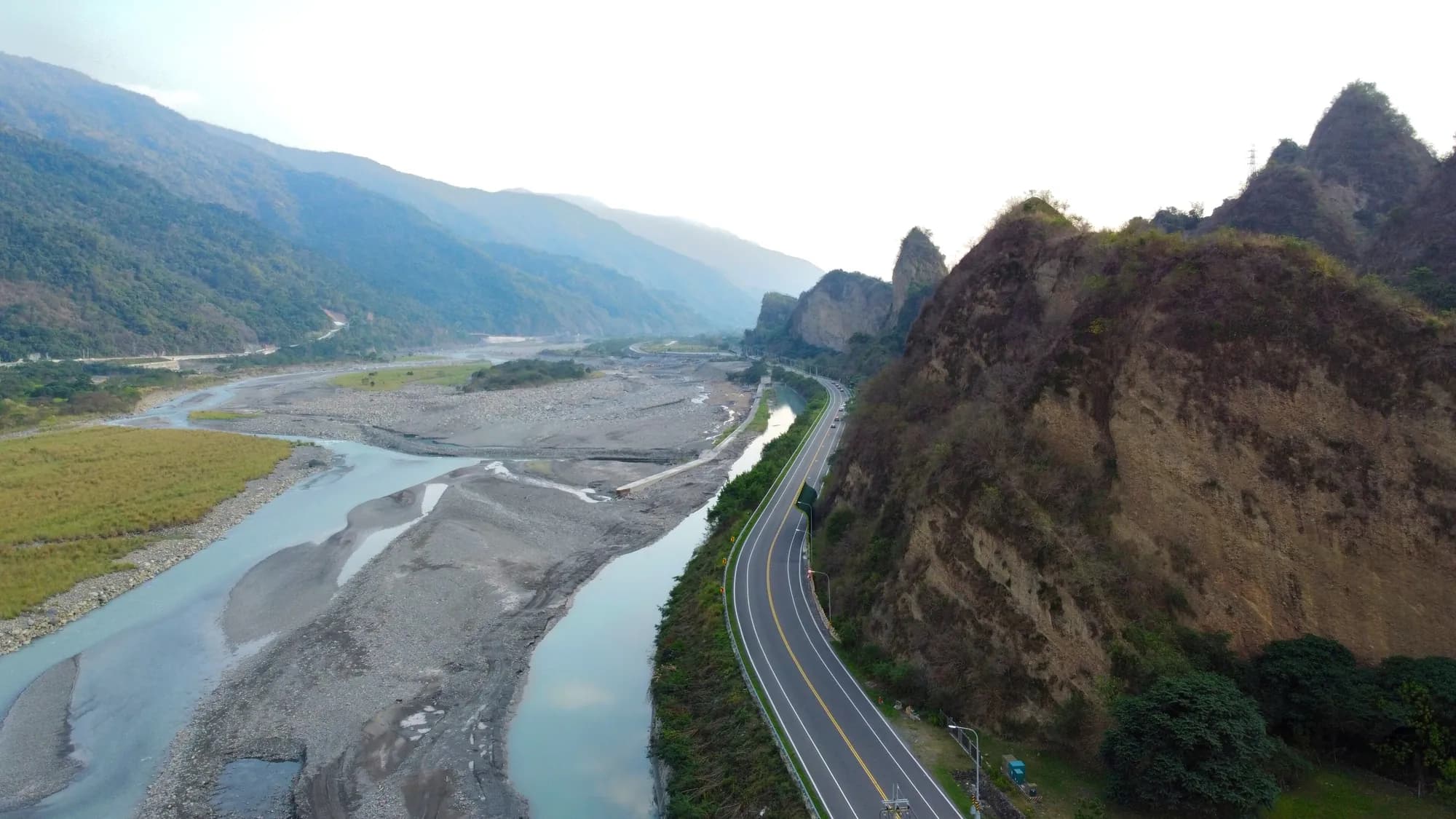 山脈與溪谷，一條道路沿著河岸延伸